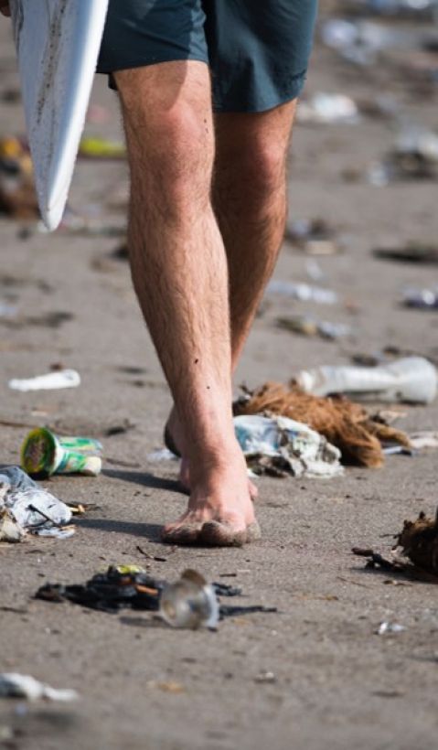 a surfer on a polluted beach